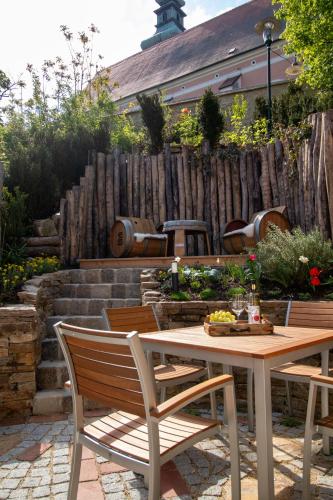 a table and chairs in a garden with a fence at Weingenuss Chalet in Poysdorf