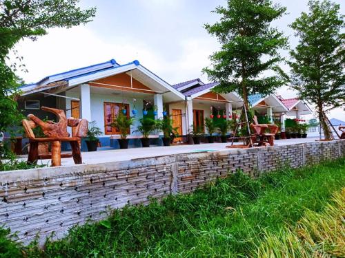 a house with a brick wall and chairs at Kiangna resort Chiang Rai in Ban Pa O (1)