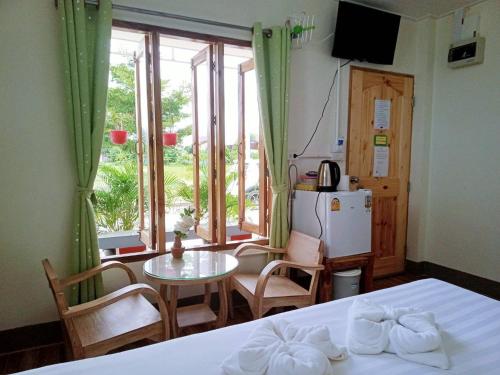 a bedroom with a bed and a table and chairs at Kiangna resort Chiang Rai in Ban Pa O (1)