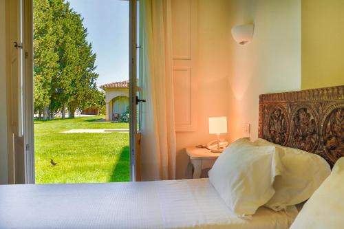 a bedroom with a bed and a door to a yard at Tartheshotel in Guspini