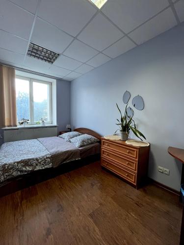 een slaapkamer met een bed, een ladekast en een raam bij Best4Rest in Kiev