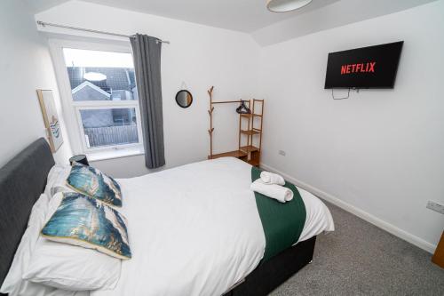 a bedroom with a bed and a window at Spacious 3 Bed Home in the heart of Swansea in Swansea