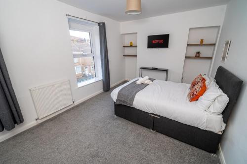 a bedroom with a bed and a window at Spacious 3 Bed Home in the heart of Swansea in Swansea