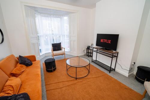 a living room with a couch and a tv at Spacious 3 Bed Home in the heart of Swansea in Swansea