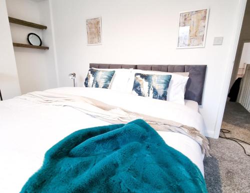 a bedroom with a bed with a blue blanket on it at Spacious 3 Bed Home in the heart of Swansea in Swansea