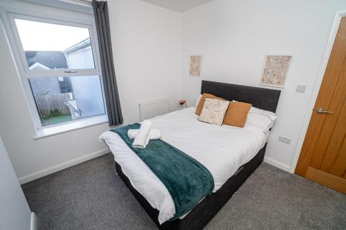 a bedroom with a large bed with a window at Spacious 3 Bed Home in the heart of Swansea in Swansea