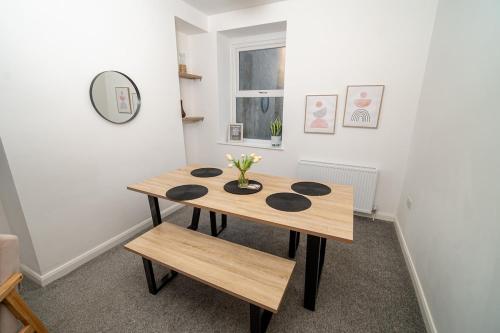 a dining room table with a vase of flowers on it at Spacious 3 Bed Home in the heart of Swansea in Swansea