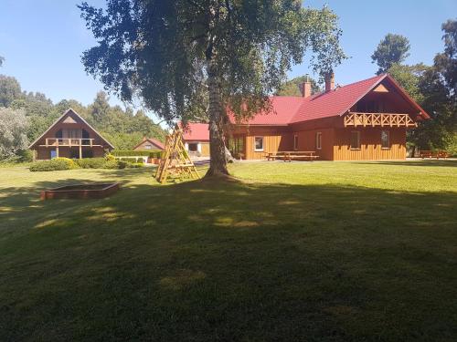 a large house with a tree in front of it at Guest house Vilciņi in Bernāti