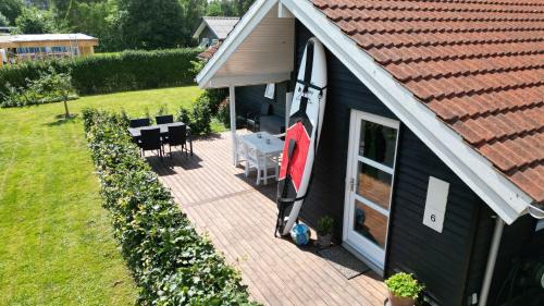 a house with a surfboard on the side of it at Moderne sommerhus, 8 senge, 250 mtr til sandstrand in Slagelse