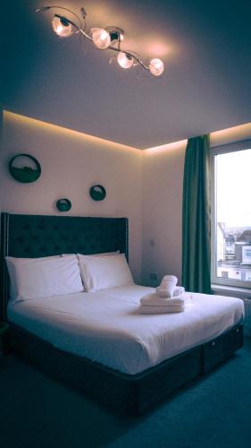 a bedroom with a large bed with a window at The Feather's Hotel Newquay in Newquay