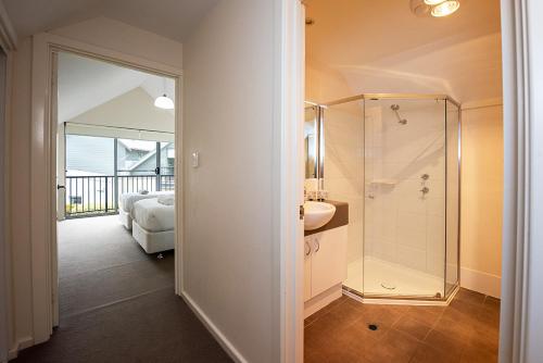 a bathroom with a shower and a bedroom with a bed at Coastal Elegance Relaxed Stay in Broadwater in Broadwater