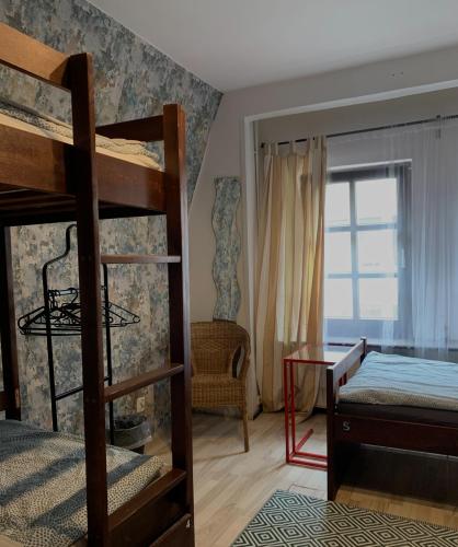 a bedroom with two bunk beds and a desk at Sunny Hostel 49 in Wrocław