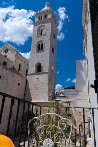 a bench in front of a building with a clock tower at Manna Blue Sky - Exclusive Rooms in Barletta