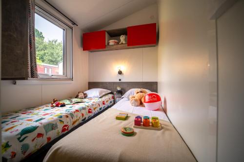 Camping des Alberes في Laroque-des-Albères: غرفة نوم بسريرين يوجد عليها حيوانات محشوة