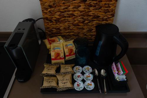 a table with a black coffee maker and some snacks at Manna Blue Sky - Exclusive Rooms in Barletta