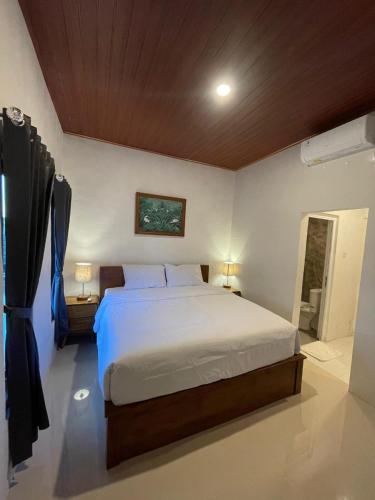a bedroom with a large bed and a bathroom at Pradnya Homestay Ungasan - Room near Uluwatu in Uluwatu