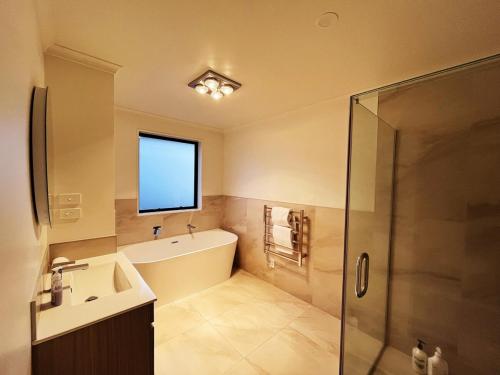 a bathroom with a tub and a sink and a shower at 7th Heaven in Rotorua in Rotorua