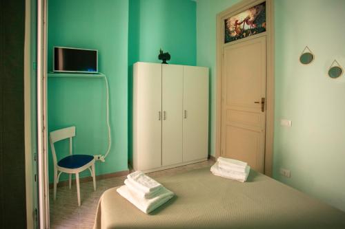 ein Schlafzimmer mit einem Bett, einem Schrank und einem Stuhl in der Unterkunft "Zigana" tra feste Siciliane - nel centro storico della città! in Palermo