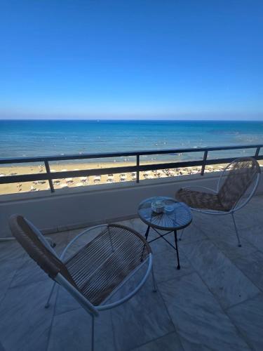 two chairs and a table on a balcony with the beach at Lazuli Skyline & Sea View Penthouse in Larnaca
