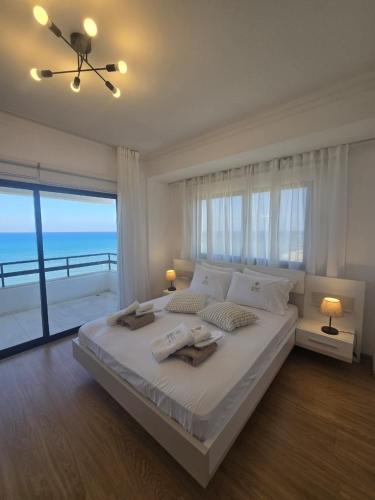 a bedroom with a large bed with a view of the ocean at Lazuli Skyline & Sea View Penthouse in Larnaca