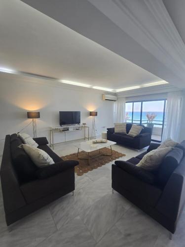 a living room with two couches and a tv at Lazuli Skyline & Sea View Penthouse in Larnaca