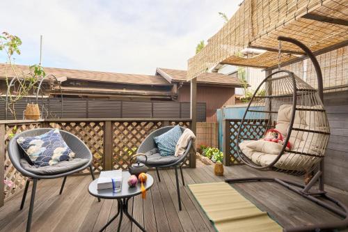 a balcony with two chairs and a swing at Family Garden House Tokyo Machida in Machida