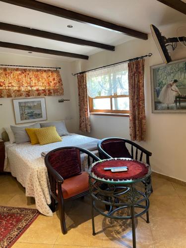 a bedroom with a bed and a table and a chair at Klein Hospitality in the Galilee Hagoshrim in Hagoshrim