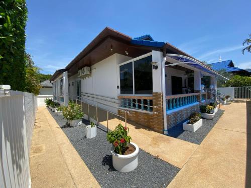 ein Haus mit Topfpflanzen davor in der Unterkunft Villa Jasmine in Rawai Beach