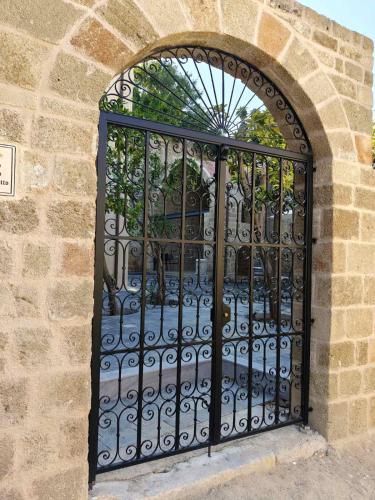 an iron gate on a building with a stone wall at Fabrizio del Carretto in Rhodes Town