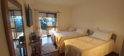 a bedroom with two beds and a window with a view at Golden House in Fátima