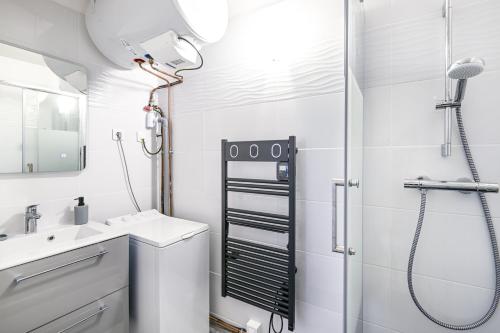 ein weißes Badezimmer mit Dusche und Waschbecken in der Unterkunft Le Vumer - Proche Plage in Courseulles-sur-Mer