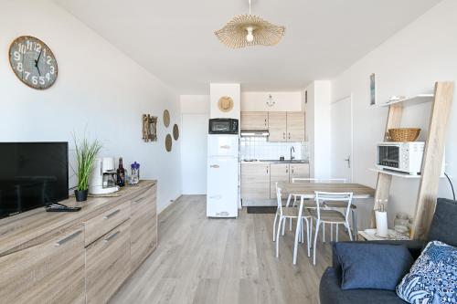 ein Wohnzimmer und eine Küche mit Tisch und Stühlen in der Unterkunft Le Vumer - Proche Plage in Courseulles-sur-Mer