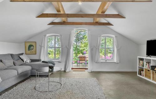 a living room with a couch and two windows at Beautiful Home In Aabenraa With House Sea View in Aabenraa