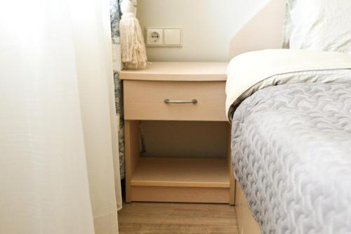 a bedroom with a bed and a nightstand next to a bed at Giruliai Holiday Apartments - VII by Prime Rentals in Melnragė