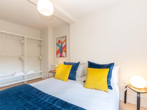 1 dormitorio con 1 cama con almohadas amarillas y azules en Beautiful Unique 2BR - Richmond near Transport Pass The Keys, en Richmond