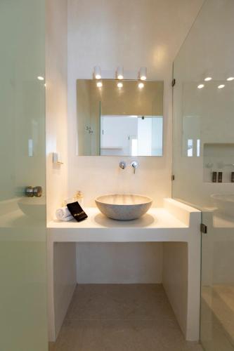 un bagno con lavabo a ciotola e specchio di Cycladic Suites a Naoussa
