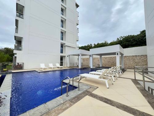 a swimming pool with chairs and a building at Oceanview Condo in Boracay in Boracay