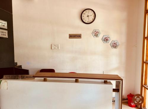 a waiting room with a clock on the wall at Hotel Paradise Premium Rasulgarh in Bhubaneshwar
