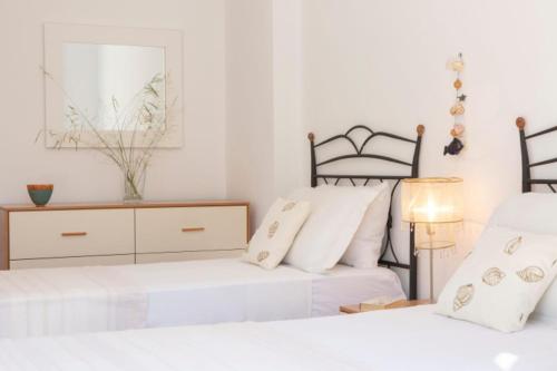 a bedroom with two beds and a dresser at VILLAS CARISMA - Natural Style Villas for 14 people in Sivota