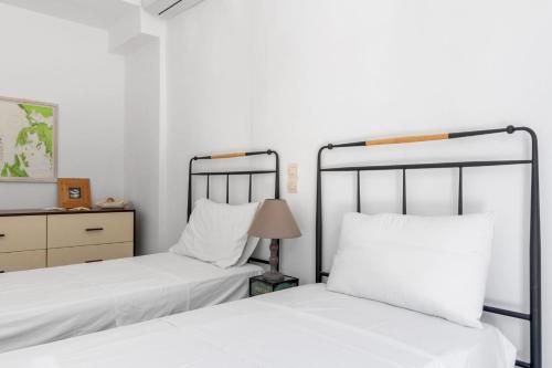 two beds in a bedroom with white walls and a lamp at VILLAS CARISMA - Natural Style Villas for 14 people in Sivota