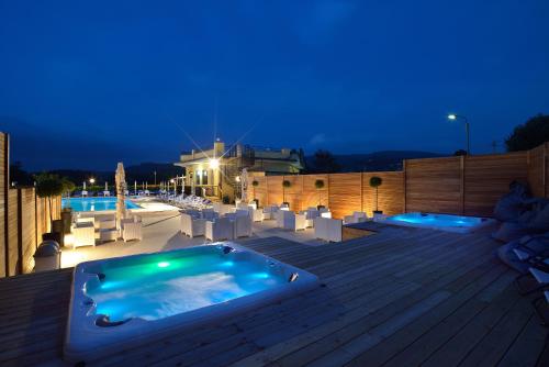a large hot tub on a deck at night at Hotel Ristorante Dante in Torgiano