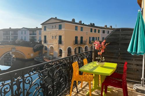 une table et des chaises sur un balcon avec vue dans l'établissement Bright duplex in the heart of Port Grimaud 1, à Grimaud