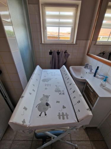 a bathroom with a table with a bear and a sink at La Grange in Verlincthun