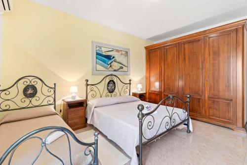 a bedroom with two beds and wooden cabinets at Casa Vacanze Antica Dimora in Scano Montiferro