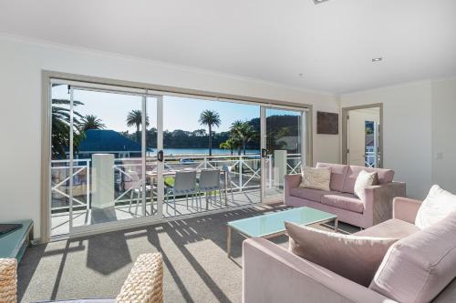 a living room with a view of the ocean at Crow's Nest Apartments in Whitianga