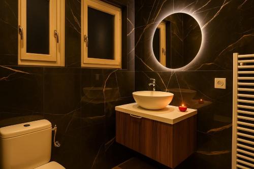 a bathroom with a sink and a toilet and a mirror at Love Room Royan in Royan