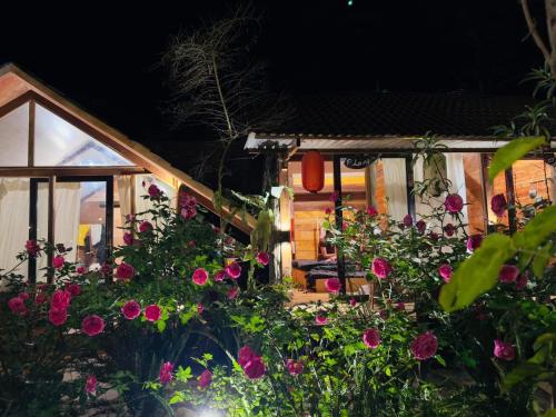 a garden with flowers in front of a house at Đồi Gió Hú Homestay & Coffee Măng Đen in Kon Von Kla