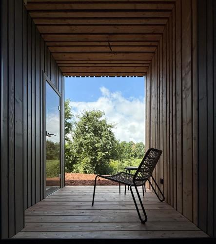 a chair sitting on the porch of a house at NEU Feinzeit Natur Lofts - Klima, Sauna, Design in Frensdorf