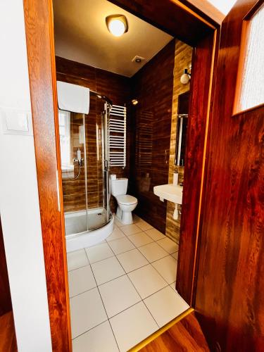 a bathroom with a toilet and a sink at Hotel Lilia in Włoszczowa