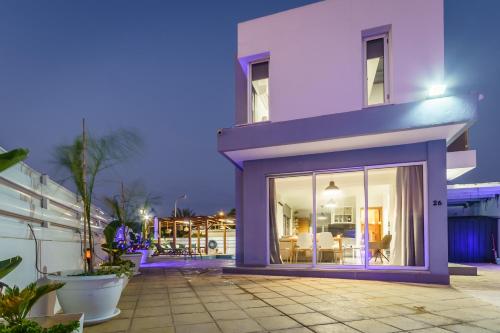 a white house with large sliding glass doors at Black Swan Villa in Pervolia